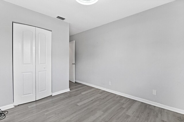 unfurnished bedroom featuring wood-type flooring and a closet