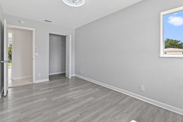 unfurnished bedroom with a closet and light wood-type flooring