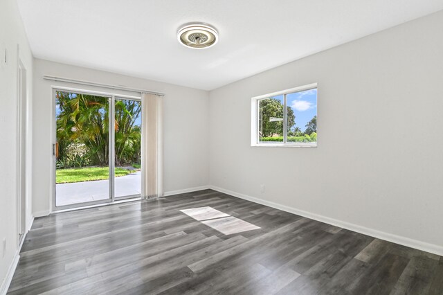 spare room with a wealth of natural light and dark hardwood / wood-style floors