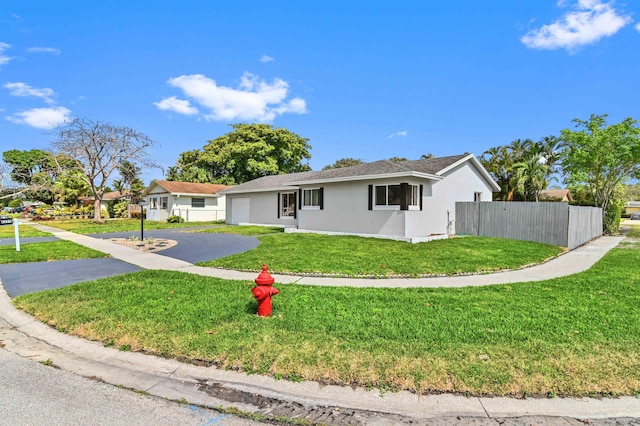 single story home featuring a garage and a front yard