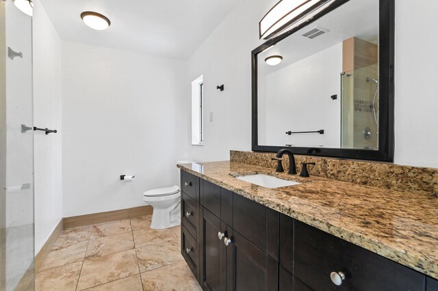 bathroom with a shower with door, toilet, tile flooring, and large vanity