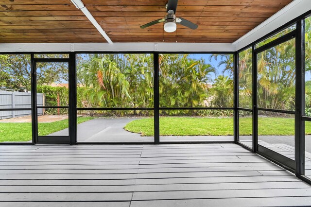 unfurnished sunroom with wood ceiling, plenty of natural light, and ceiling fan