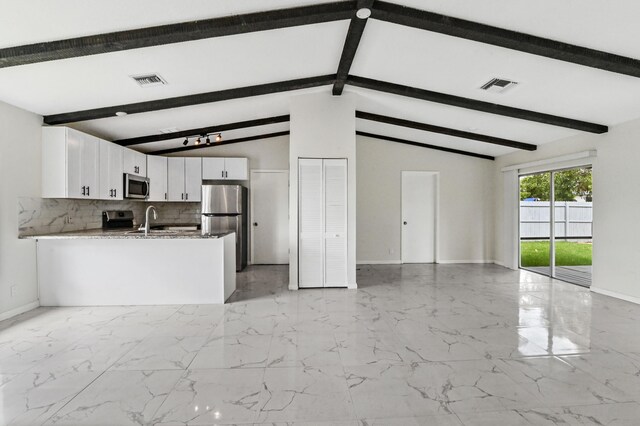 kitchen featuring beam ceiling, light tile floors, stainless steel appliances, and white cabinetry