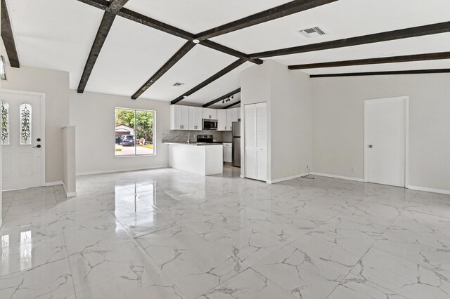 unfurnished living room featuring vaulted ceiling with beams and light tile floors