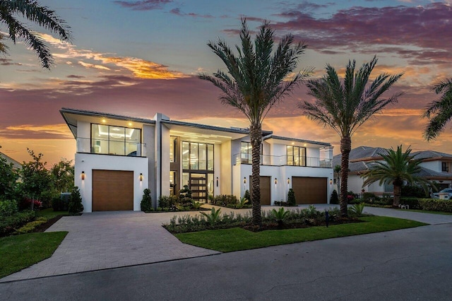 contemporary house with french doors, a balcony, and a garage