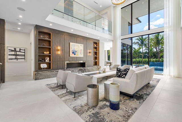 tiled living room with a fireplace, built in features, and a high ceiling