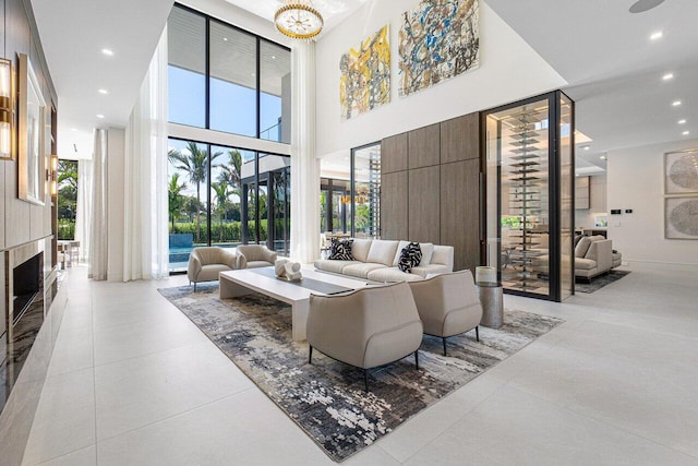 tiled living room featuring a towering ceiling and an inviting chandelier