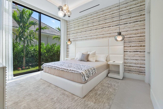 bedroom with wood walls and a notable chandelier