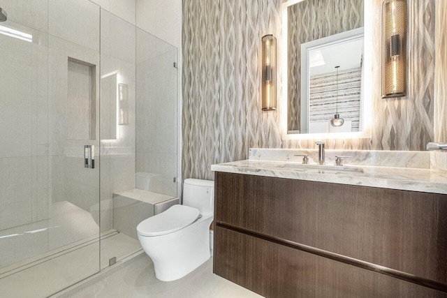 bathroom featuring vanity, toilet, a shower with door, and tile walls