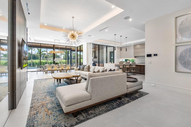 living room featuring a raised ceiling, a wall of windows, light tile patterned floors, and a chandelier