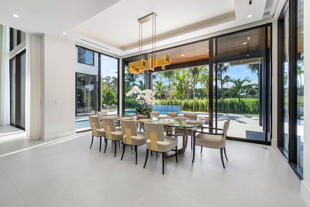 tiled dining space featuring a raised ceiling