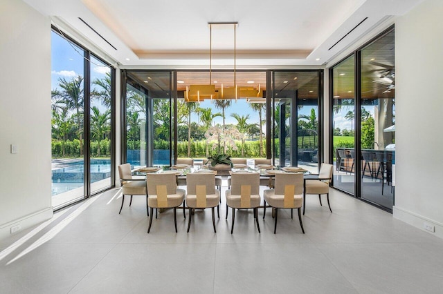 dining space featuring a wall of windows, a tray ceiling, and plenty of natural light