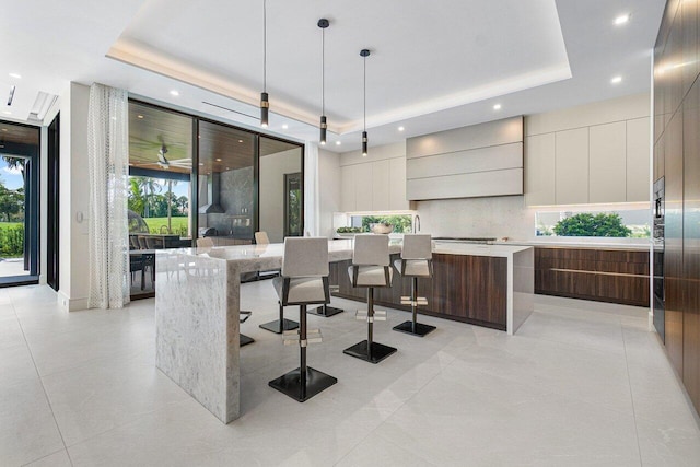 tiled dining area featuring a tray ceiling