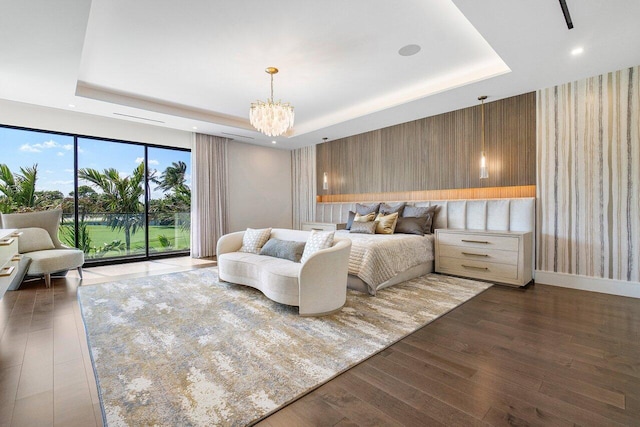 bedroom with access to exterior, an inviting chandelier, a raised ceiling, and dark hardwood / wood-style floors