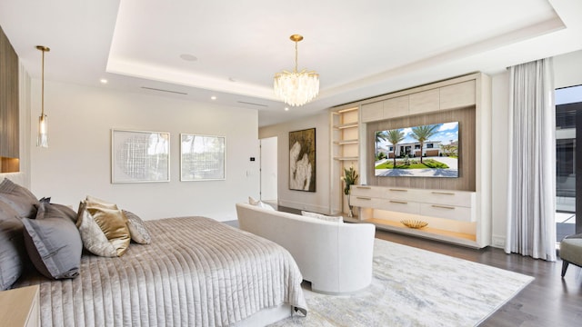 bedroom with dark wood-type flooring, a tray ceiling, and a notable chandelier