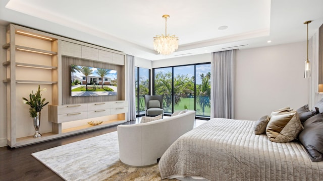 bedroom featuring a chandelier, dark hardwood / wood-style flooring, a tray ceiling, and access to exterior