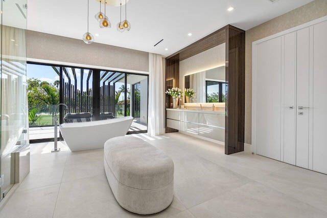 bathroom featuring vanity, a tub to relax in, and a wealth of natural light