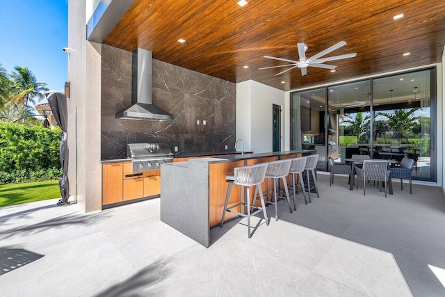 view of patio with ceiling fan, a grill, area for grilling, and a wet bar