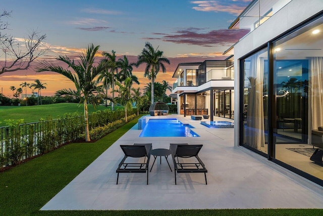 pool at dusk featuring a patio