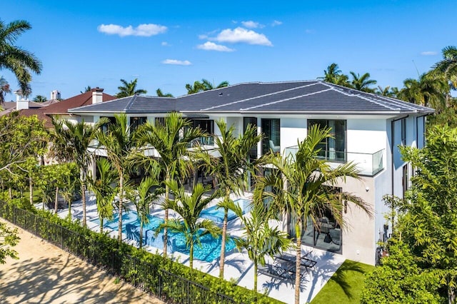 exterior space featuring a balcony, a fenced in pool, and a patio area