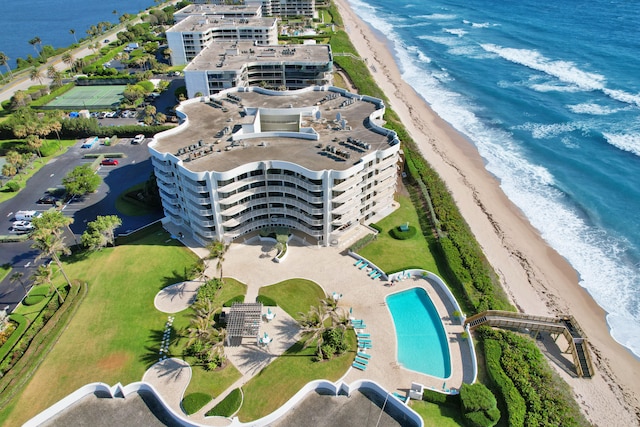 birds eye view of property with a water view and a beach view