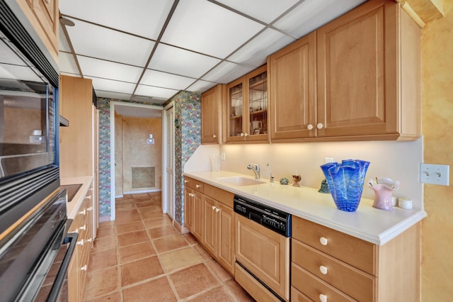 kitchen with light tile floors, sink, a drop ceiling, paneled dishwasher, and black oven