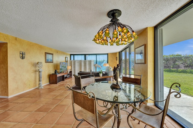 dining room with an inviting chandelier, light tile floors, and a textured ceiling