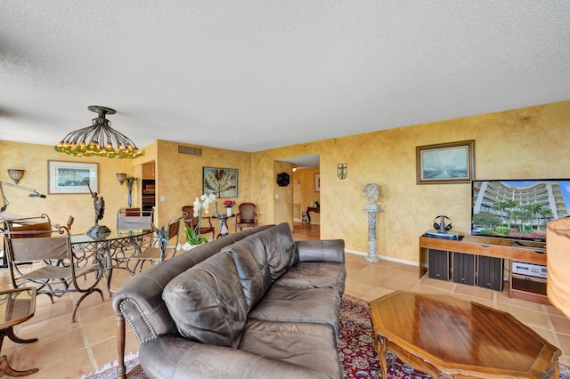 living room featuring light tile flooring, a chandelier, and a textured ceiling