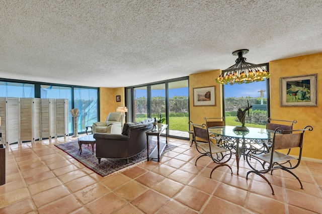 tiled living room featuring a chandelier, floor to ceiling windows, and a textured ceiling