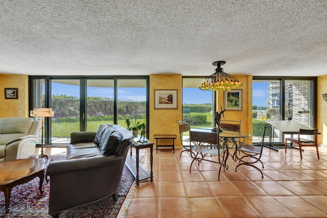 living room with a wall of windows, tile flooring, and a textured ceiling