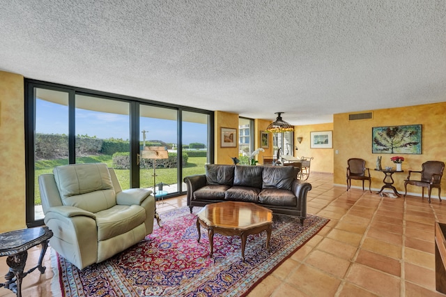 tiled living room featuring a wall of windows and a textured ceiling