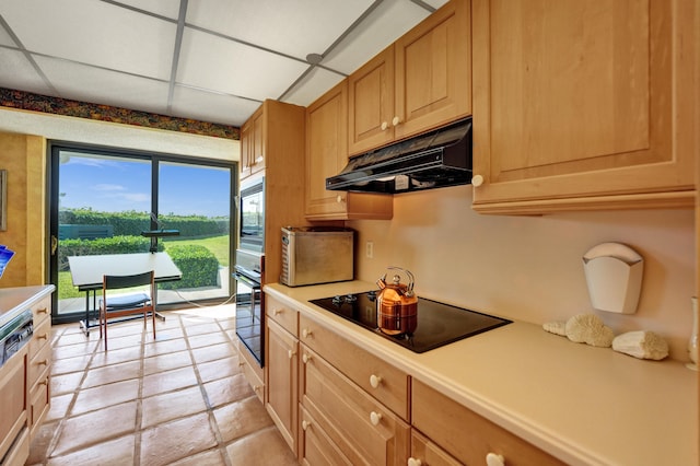 kitchen featuring black electric stovetop, a paneled ceiling, and light tile flooring