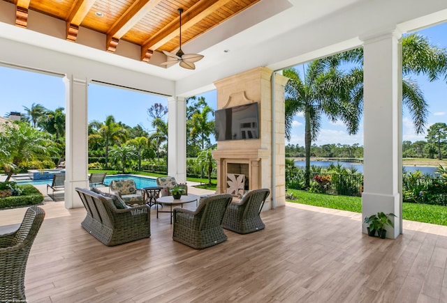 exterior space featuring area for grilling, an outdoor living space with a fireplace, an outdoor bar, and ceiling fan