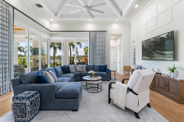 living room featuring light hardwood / wood-style flooring, ceiling fan, coffered ceiling, and ornamental molding