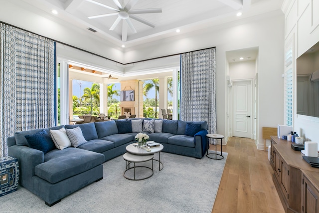 living room with hardwood / wood-style floors, ceiling fan, and coffered ceiling