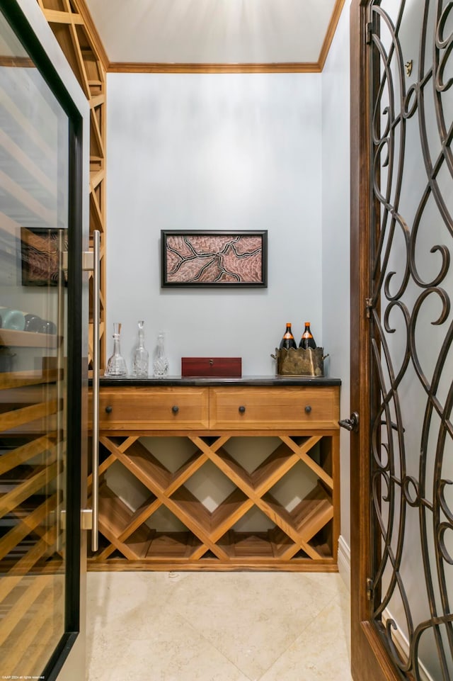 wine cellar with tile flooring and ornamental molding