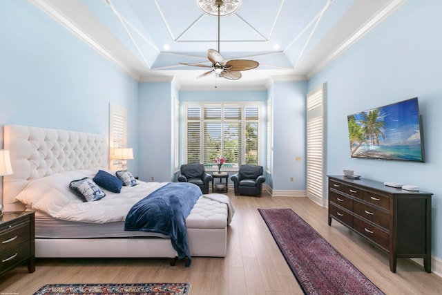 bedroom with hardwood / wood-style floors, ceiling fan, a tray ceiling, and crown molding