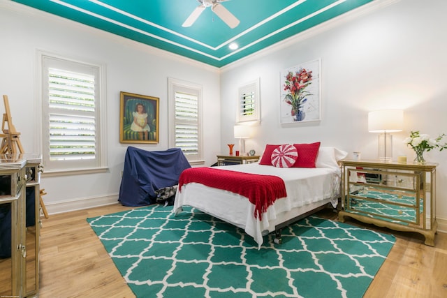 bedroom featuring hardwood / wood-style floors, ceiling fan, and crown molding