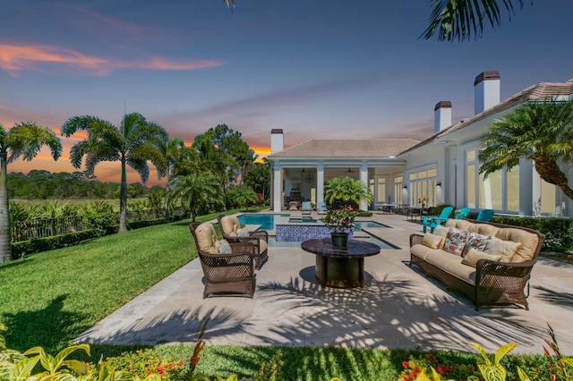 patio terrace at dusk featuring a yard and an outdoor hangout area