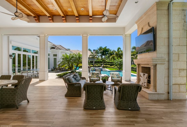 sunroom featuring wood ceiling, a wealth of natural light, beam ceiling, and ceiling fan