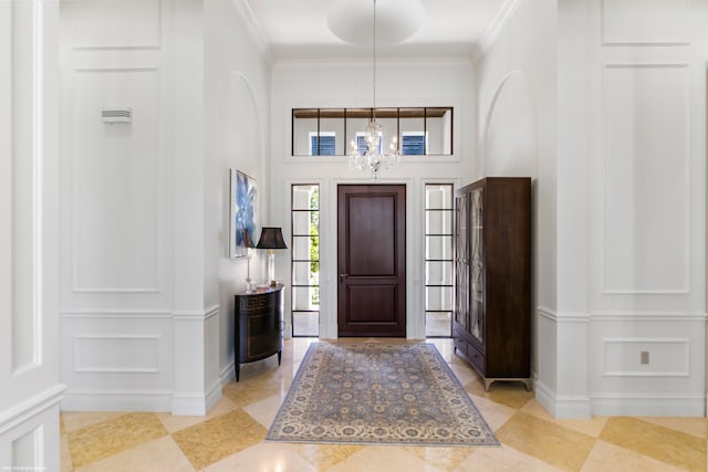 entryway with an inviting chandelier, light tile flooring, and ornamental molding