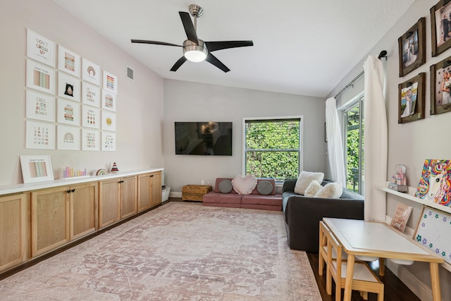 living room featuring vaulted ceiling and ceiling fan