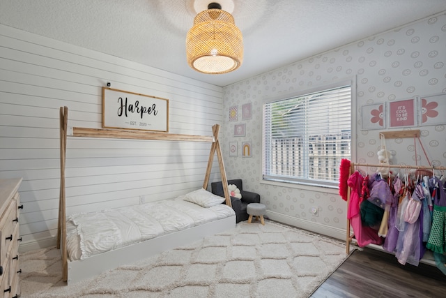 bedroom with a textured ceiling and hardwood / wood-style flooring