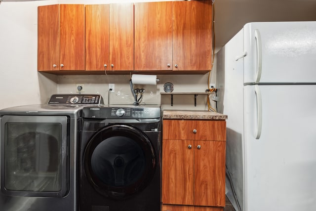 clothes washing area with hookup for a washing machine, cabinets, and washer and dryer