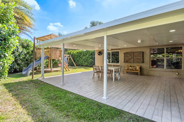 deck with a playground and a yard