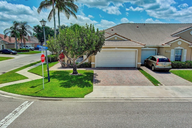 ranch-style home featuring a garage and a front lawn