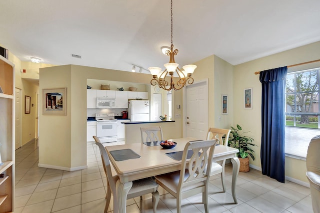 tiled dining area featuring lofted ceiling and a notable chandelier