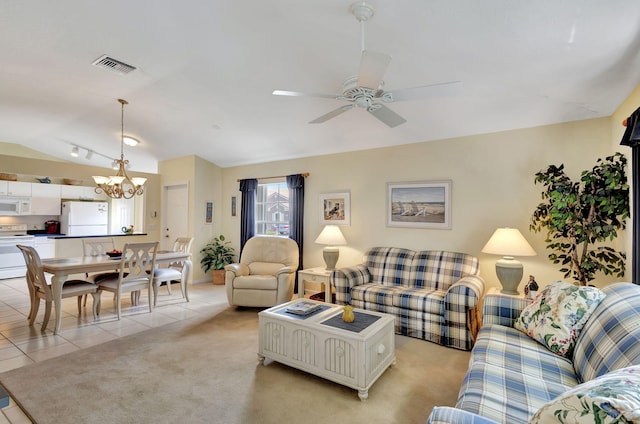 tiled living room with ceiling fan with notable chandelier and rail lighting