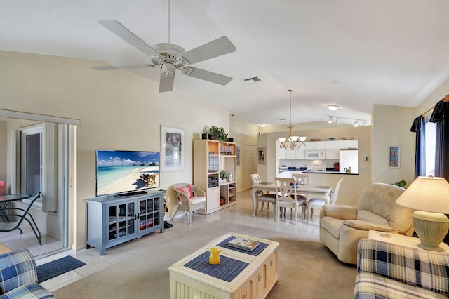 living room with ceiling fan with notable chandelier, vaulted ceiling, and light tile floors