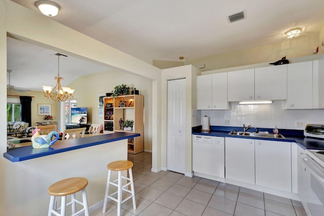 kitchen featuring light tile flooring, white cabinetry, white dishwasher, sink, and tasteful backsplash